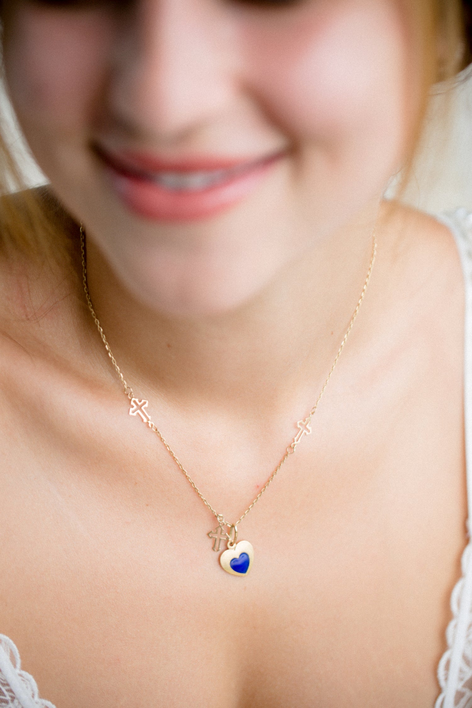 beautiful girl wearing a gold hearth shape necklace with sapphire in the middle