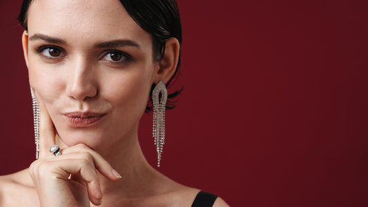 A close-up photo of a woman wearing elegant diamond earrings.