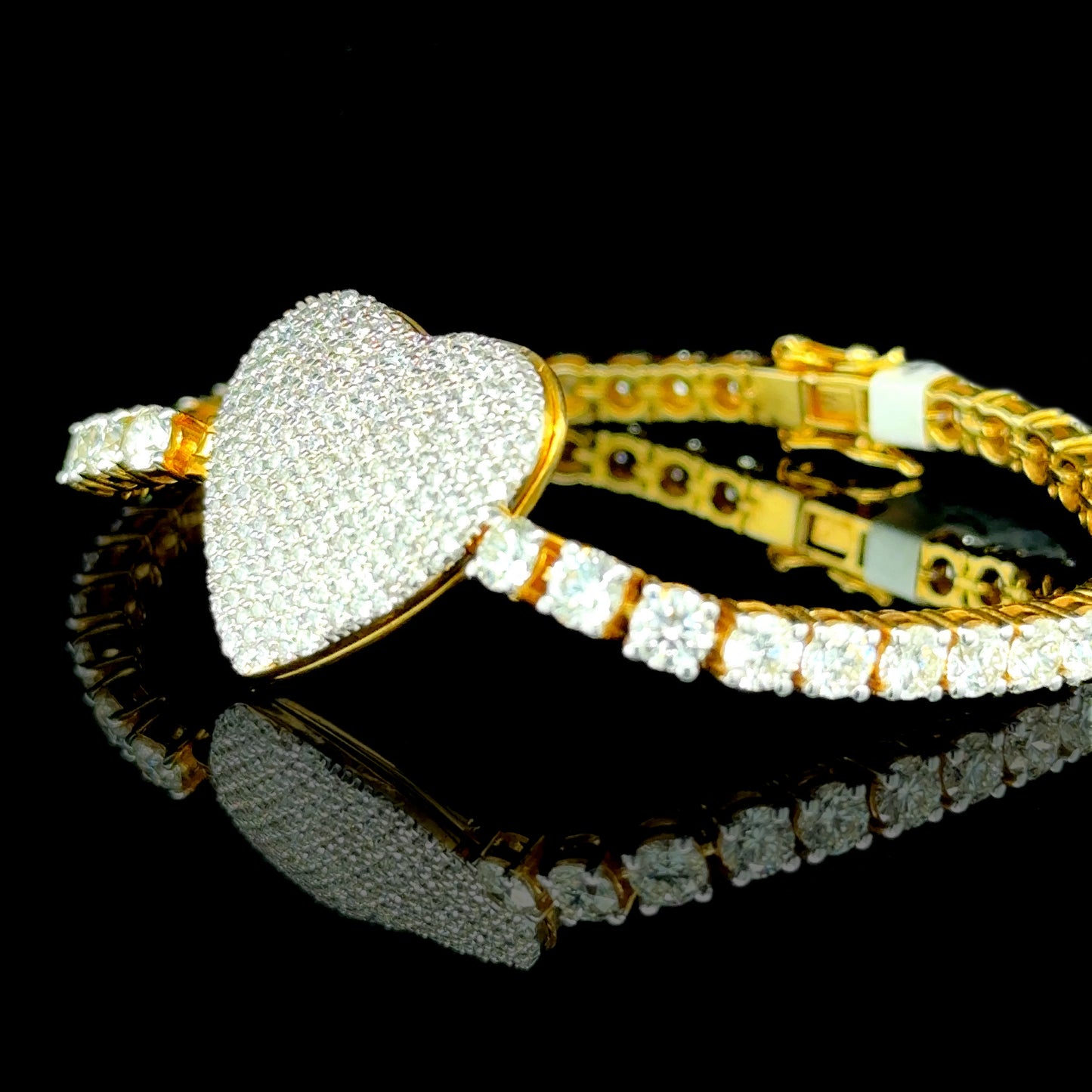 Statement yellow gold tennis bracelet with heart-shaped diamonds.