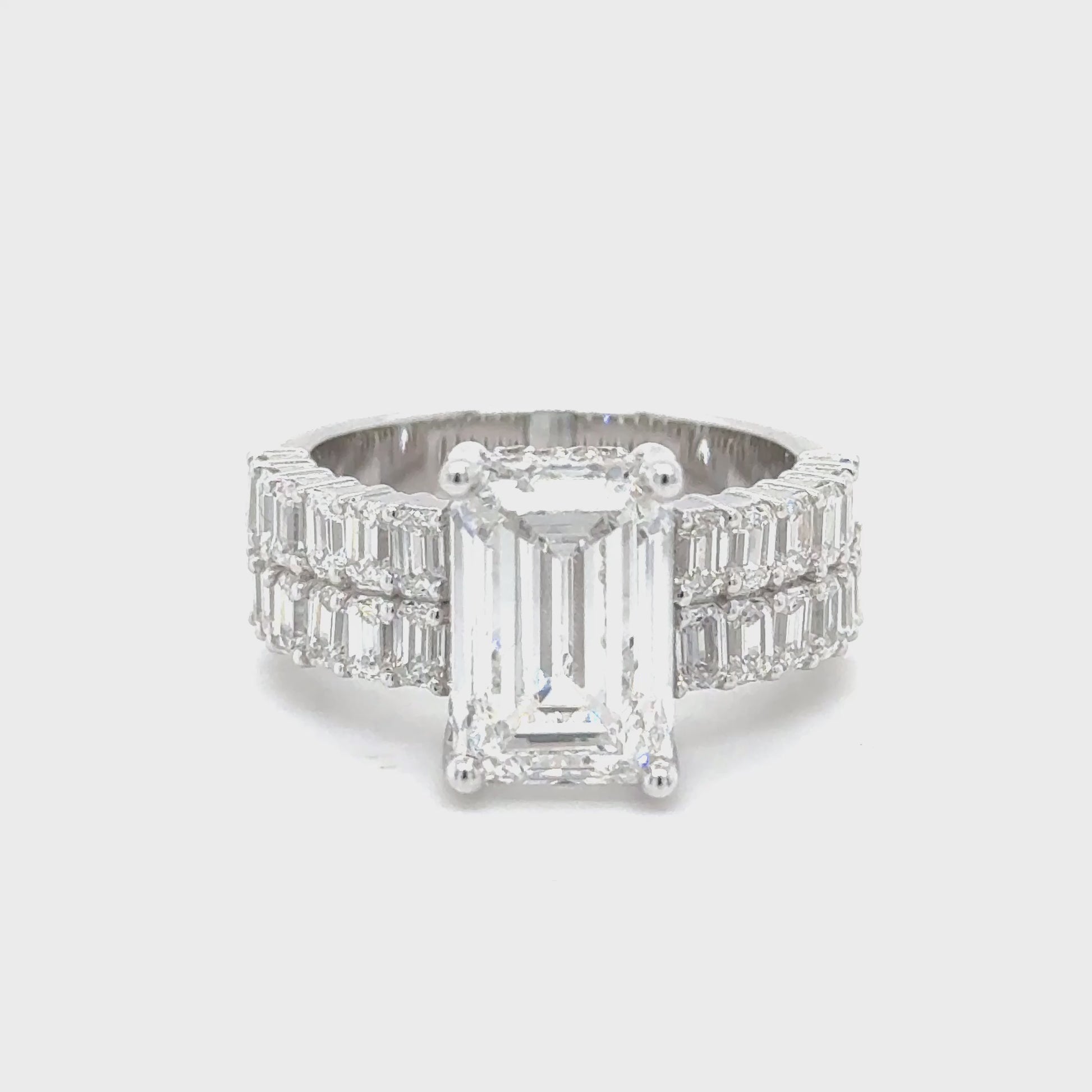 14K white gold engagement ring featuring a 5 carat emerald cut lab grown diamond with VS1 clarity and E color, accented by 2.25 carats of lab grown diamonds.